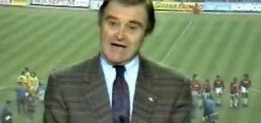 A man in a suit and tie is on a television screen